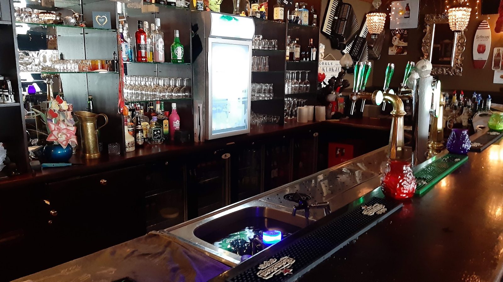 Achter de bar langs, met de tapkranen en de flessen in het licht