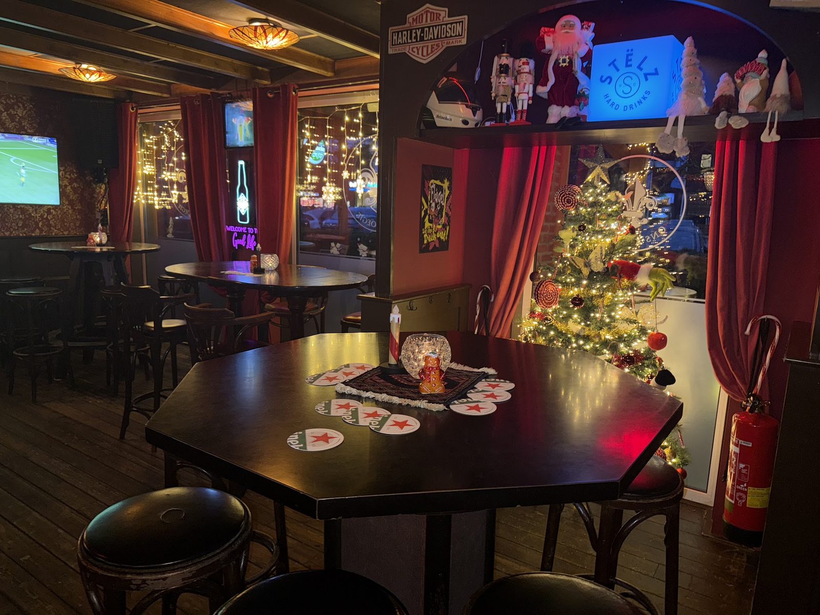 De gelagkamer met kerstboom, schermen en een Harley-Davidson-bord aan de muur