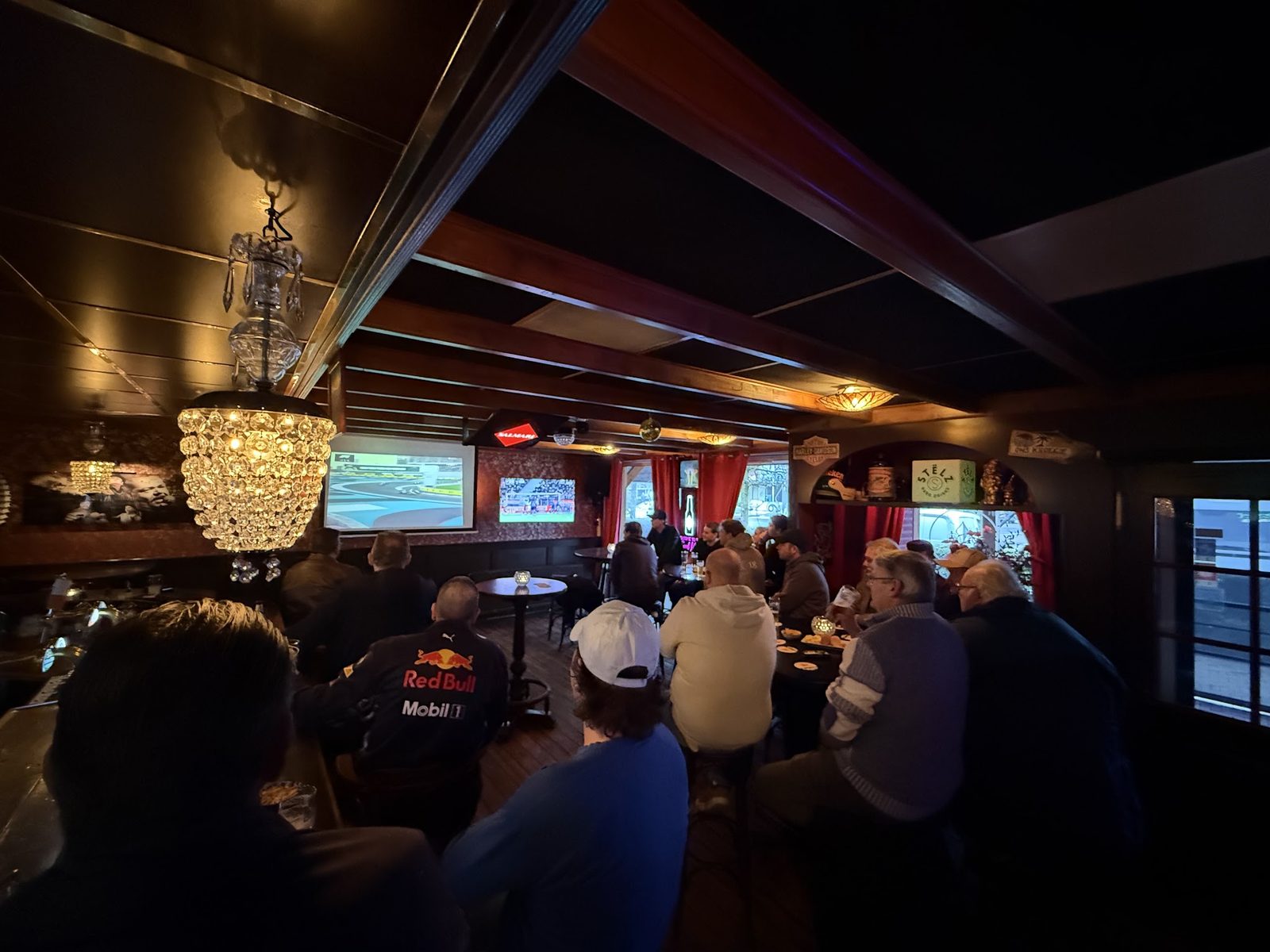 Gasten die naar de schermen boven de bar kijken